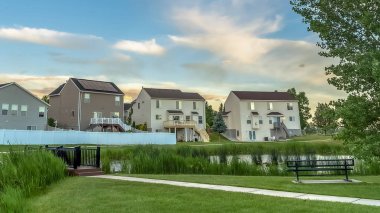 Balkonlu evlerin önündeki parkta panorama çerçeve Pond köprü yolu ve bank