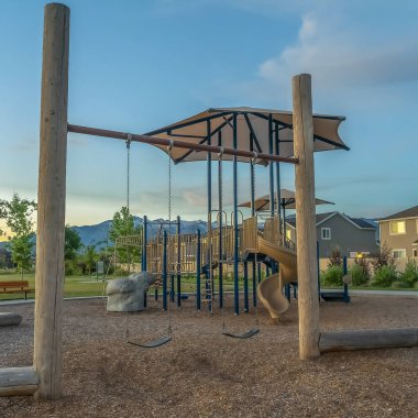 Square Playground ve dağ ve bulutlu mavi gökyüzü manzaralı bir mahallede evler