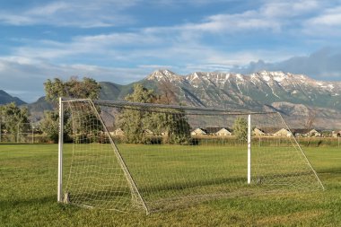 Kar kaplı dağ ve bulutlu gökyüzü arka plan ile bir spor alanında Futbol net
