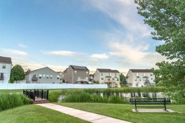 Bankköprü ve arka planda aile evlerinin görünümü ile bir gölet bakan