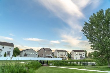 Balkonlu evlerin önündeki parkta gölet köprü yolu ve bank