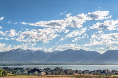 Mavi bir göle ve yükselen dağa bakan evleri ile pitoresk manzara