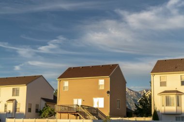 Güneşli bir günde dağ ve bulutlu gökyüzüne karşı yatay duvara sahip evler