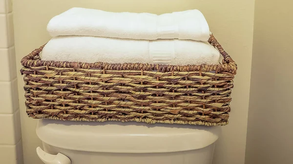 Panorama vikta handdukar inuti en rotting bad rums bricka placeras ovanpå toaletten tanken — Stockfoto
