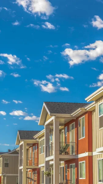 Casas verticais com parede exterior branca e laranja contra céu azul nublado em um dia ensolarado — Fotografia de Stock