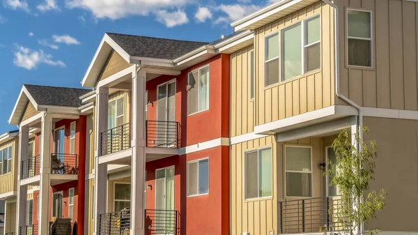 Panorama Bulutlu mavi gökyüzüne karşı beyaz ve turuncu duvar kombinasyonu ile renkli ev