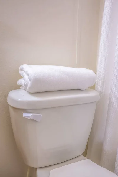 Primer plano del inodoro de un baño con una toalla doblada en la parte superior del tanque —  Fotos de Stock