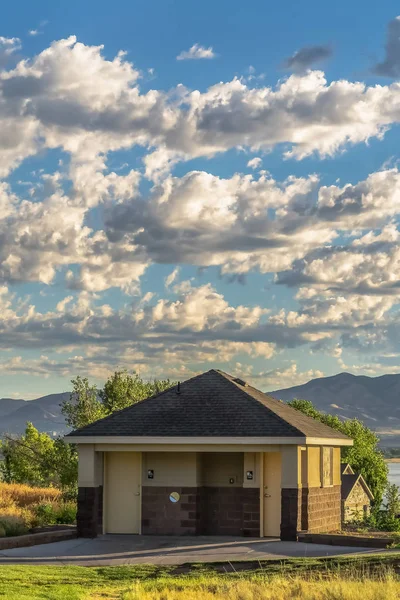 Baño público en un parque con vista al lago y la montaña en el fondo — Foto de Stock