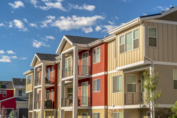 Bulutlu mavi gökyüzüne karşı beyaz ve turuncu duvar kombinasyonu ile renkli ev