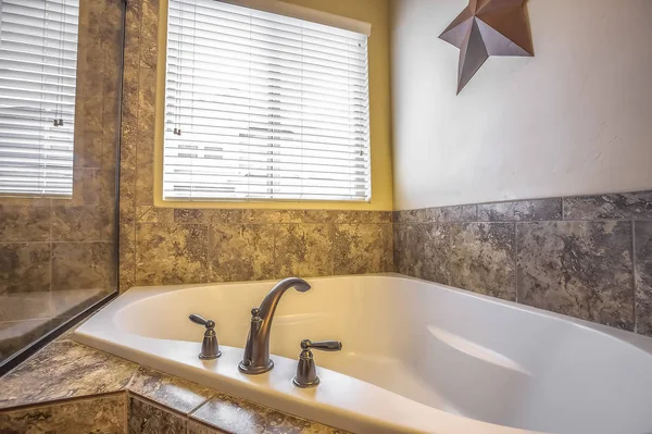 Close up of the clean white built in bathtun of a bathroom with marble tile wall — Stock Photo, Image