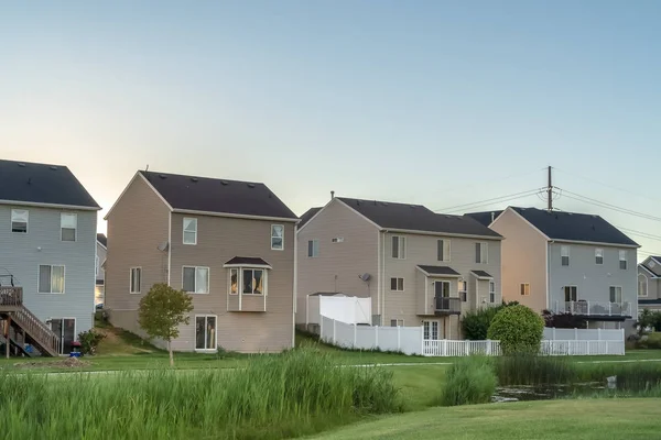 Fachada de casas de varios pisos con patios de hierba con vistas al parque con pequeño estanque — Foto de Stock