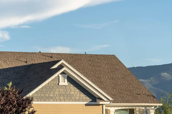 Gros plan du toit d'une maison contre le ciel bleu et la montagne par une journée ensoleillée — Photo