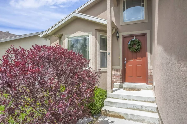 Çelenk ile süslenmiş kahverengi ön kapı ile bir evin girişinde Merdivenler