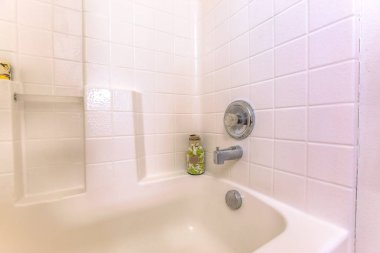 Bathroom interior with close up view of the bathtub and white tiled wall