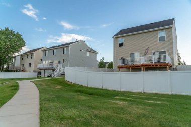 Merdivenleri ve balkonları olan evlerin önündeki patika ve çimenler