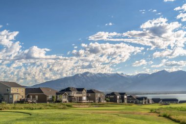 Arka planda göl ve dağ ile Golf sahası ve yerleşim alanı