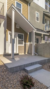 Dikey çerçeve Güneşli bir günde balkonlu ve kayalık bahçeli kasaba evleri