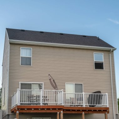 Beyaz yatay duvar kaplaması ve mavi gökyüzüne bakan balkonu olan Square Home