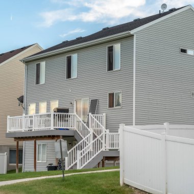 Kare çerçeve Gri yatay ahşap kaplamalı ve merdivenleri balkona çıkan bir ev