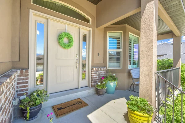 Puerta delantera con ventana de coronas y laterales en la fachada de una casa — Foto de Stock