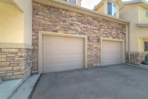 White garage doors of a home against exterior wall covered with stone bricks — Stock Photo, Image