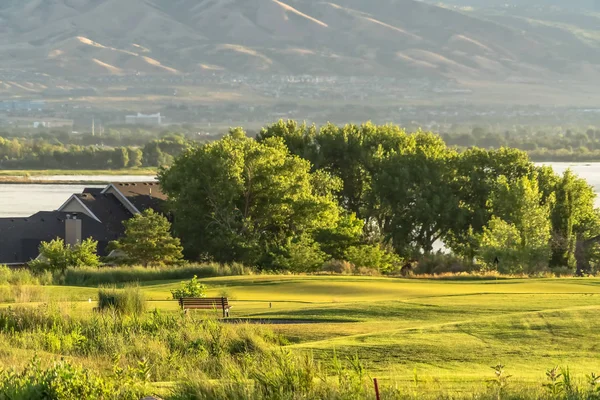 Casas abundantes árboles y campo de golf con un lago pintoresco en el fondo —  Fotos de Stock