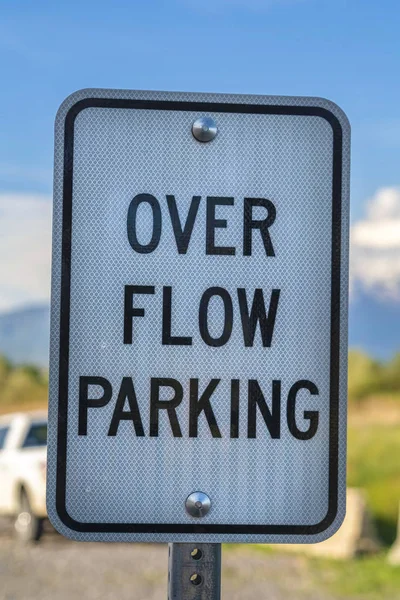 Nahaufnahme eines weißen und schwarzen rechteckigen Schildes, das über Flow Parking steht — Stockfoto