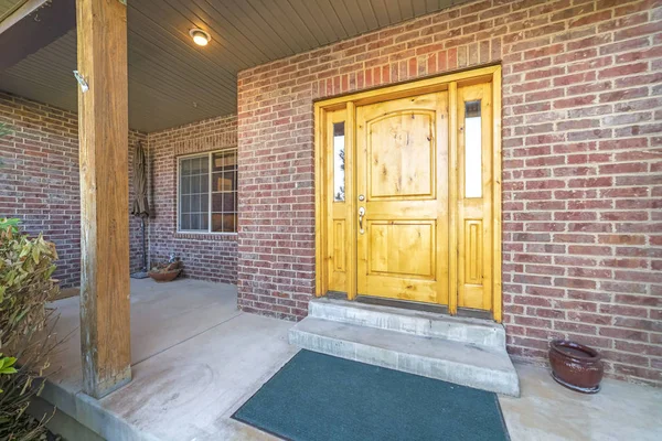 Porte d'entrée brun clair brillant avec feux latéraux d'une maison avec mur de briques rouges — Photo