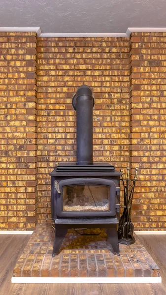 Fireplace intalled on a brick platform and against the stone brick accent wall