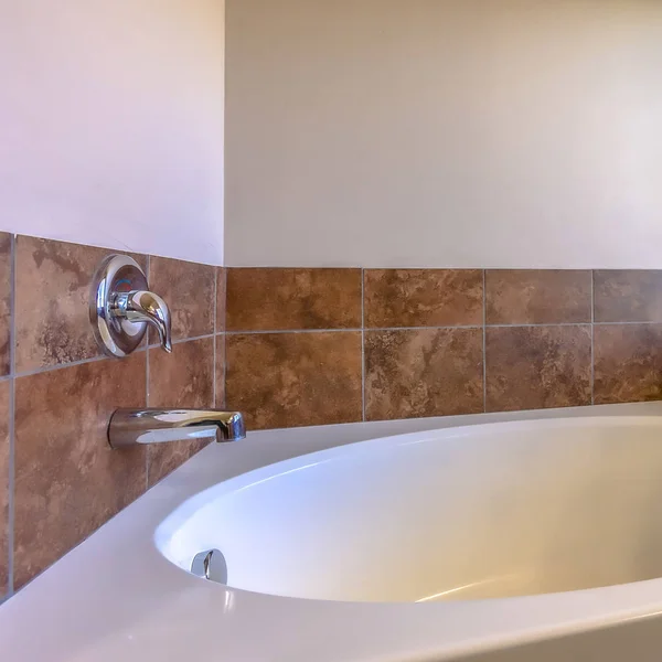 Square Close up of built in oval bathtub inside a bathroom with tiled and concrete wall — Stock Photo, Image