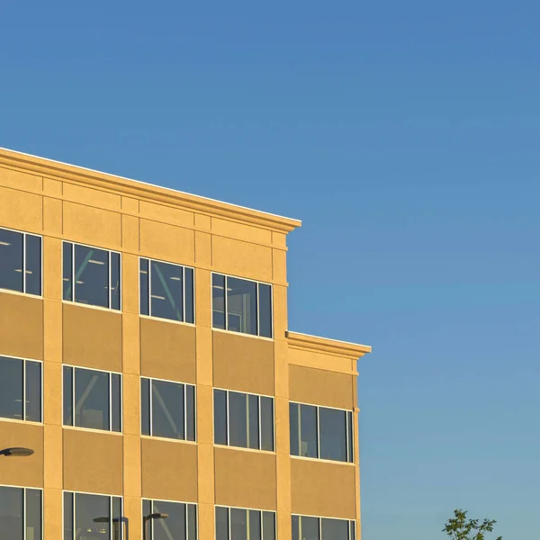 화창 한 날 하늘을 배경으로 파란색으로 보이는 현대식 건물 의외부는 정사각형 모양이었다 — 스톡 사진