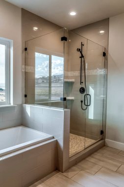 Rectangular walk in shower stall with half glass enclosure and black shower head clipart