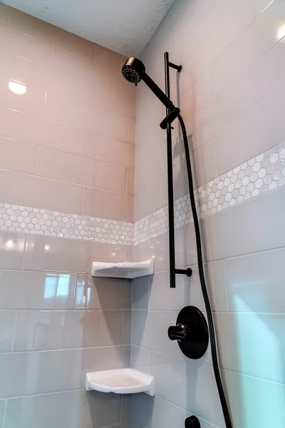 Black round shower head and handle inside the walk in bathroom shower stall