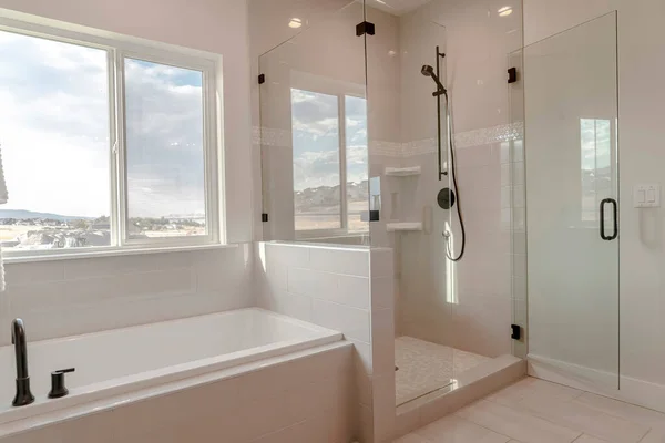 Built in bathtub with black faucet and shower stall with half glass enclosure — Stock Photo, Image