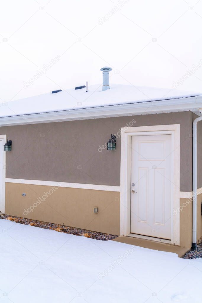 Building facade with white doors and outdoor lights against gray and brown wall