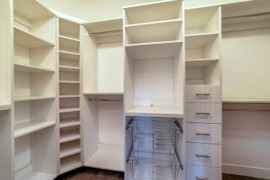 Dolabın içinde raflarda asılı çekmeceler ve metal sepetlerle yürüyün.