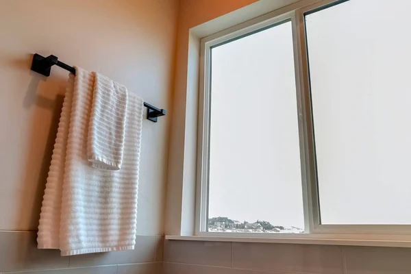 Interiör i badrum med vit handduk hängande på svart stång monterad på väggen — Stockfoto