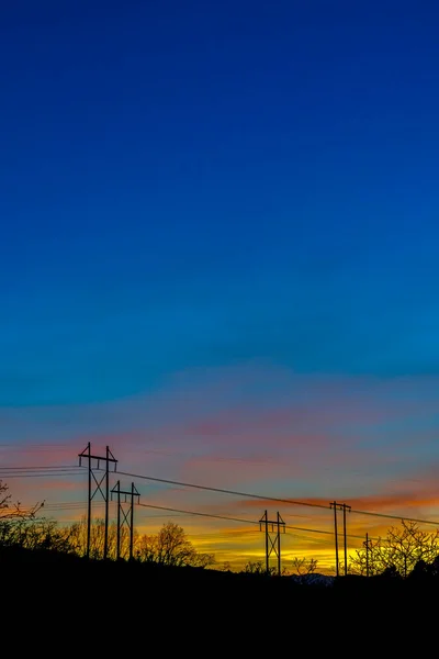 Postes de electricidad siluetas contra el cielo azul en Provo Canyon Utah al atardecer —  Fotos de Stock