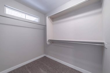 Küçük pencere halısı döşemeli ve beyaz duvarlı dolap içi boş bir yürüyüş