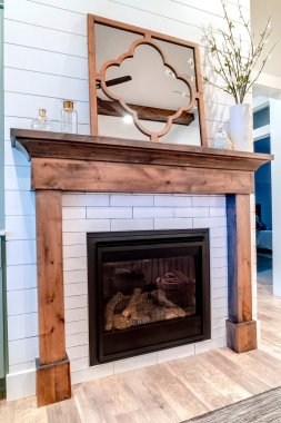 Beyaz aksanlı oturma odası duvarına karşı ahşap çerçeveli modern şömine.