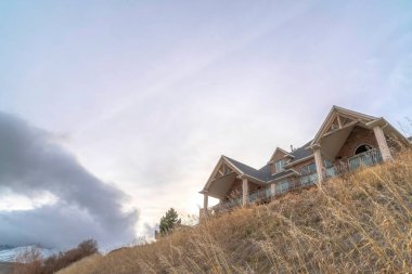 Mahalledeki evimde, karlı dağın tepesinde ve bulutlu gökyüzünde oturuyorum.