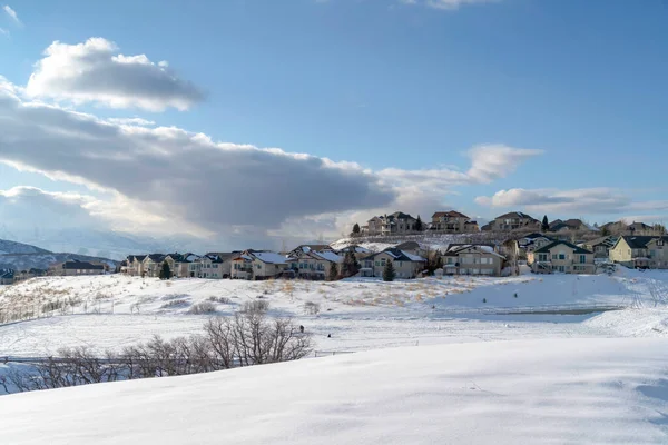 Wasatch Mountain en invierno con casas en hectáreas soleadas de terreno cubierto de nieve — Foto de Stock