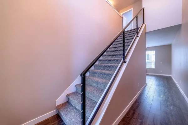 Indoor staircase against brown wooden floor and plain white wall of home