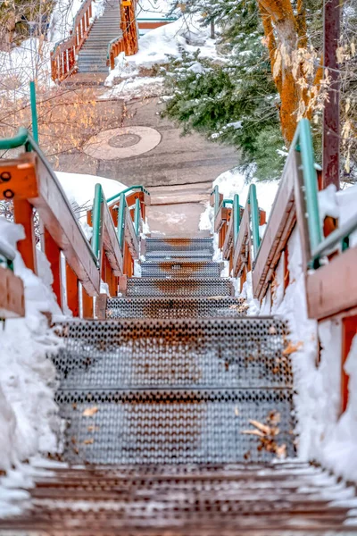 Escadaria descendo a uma estrada em uma colina com neve branca fresca no inverno — Fotografia de Stock