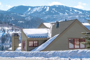 Kış mevsiminde bulanık dağ ve gökyüzüne karşı evin çatısı karla kaplı.
