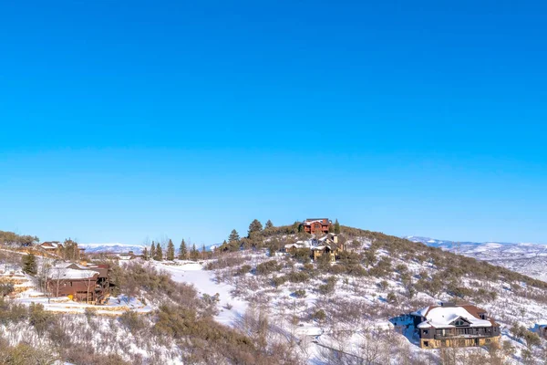Paisaje de casas en la cima de la montaña cubierta de nieve contra el cielo azul en Park City Utah — Foto de Stock