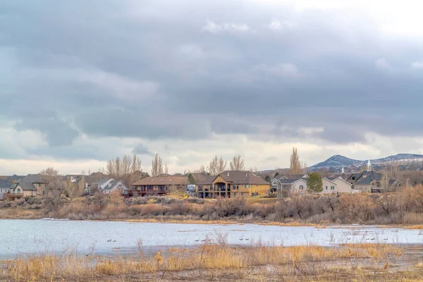 Ciel avec des nuages gris épais sur le paysage résidentiel surplombant le paysage du lac — Photo