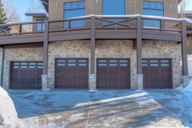 Park City Utah mahallesindeki karlı bir evin balkonunun altındaki garaj kapısı.