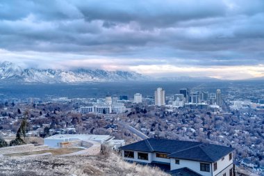Salt Lake City şehir merkezine bakan tepe ve karla kaplanmış uzak dağ