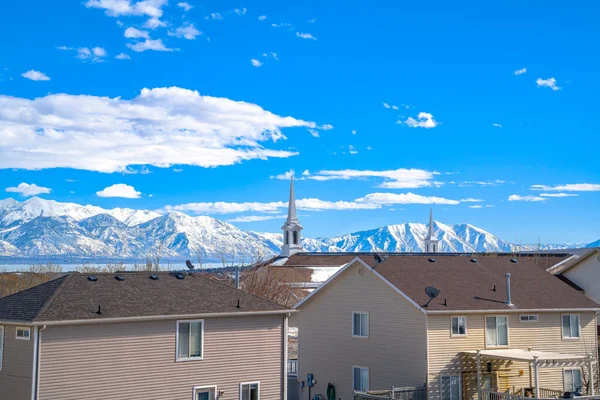 Casas en el valle contra el lago montaña nevada y cielo nublado en un día soleado —  Fotos de Stock